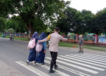 Menyeberangi Jalan Polisi Berikan Rasa Aman Pelajar di Lembak